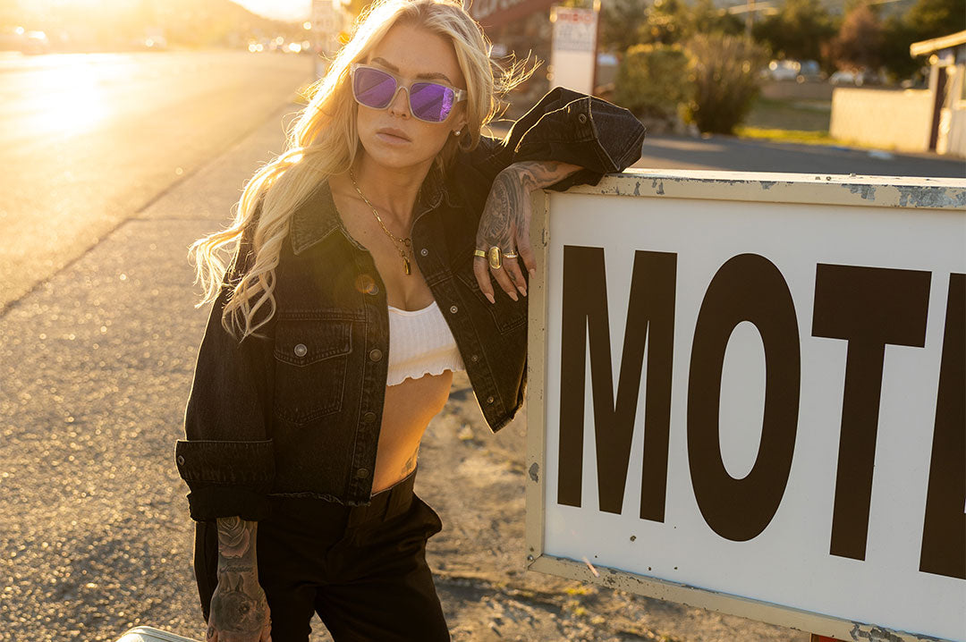 Woman wearing purple mirrored sunglasses outdoors
