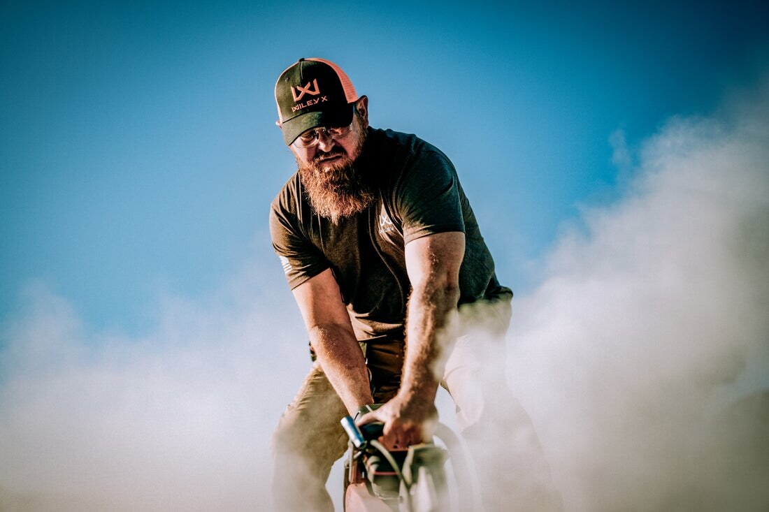 Worker in safety glasses grinding metal as sparks fly