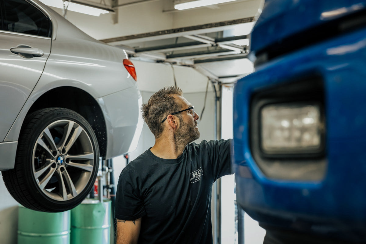 Mechanic wearing Wiley X frames beside a pickup truck in an auto shop