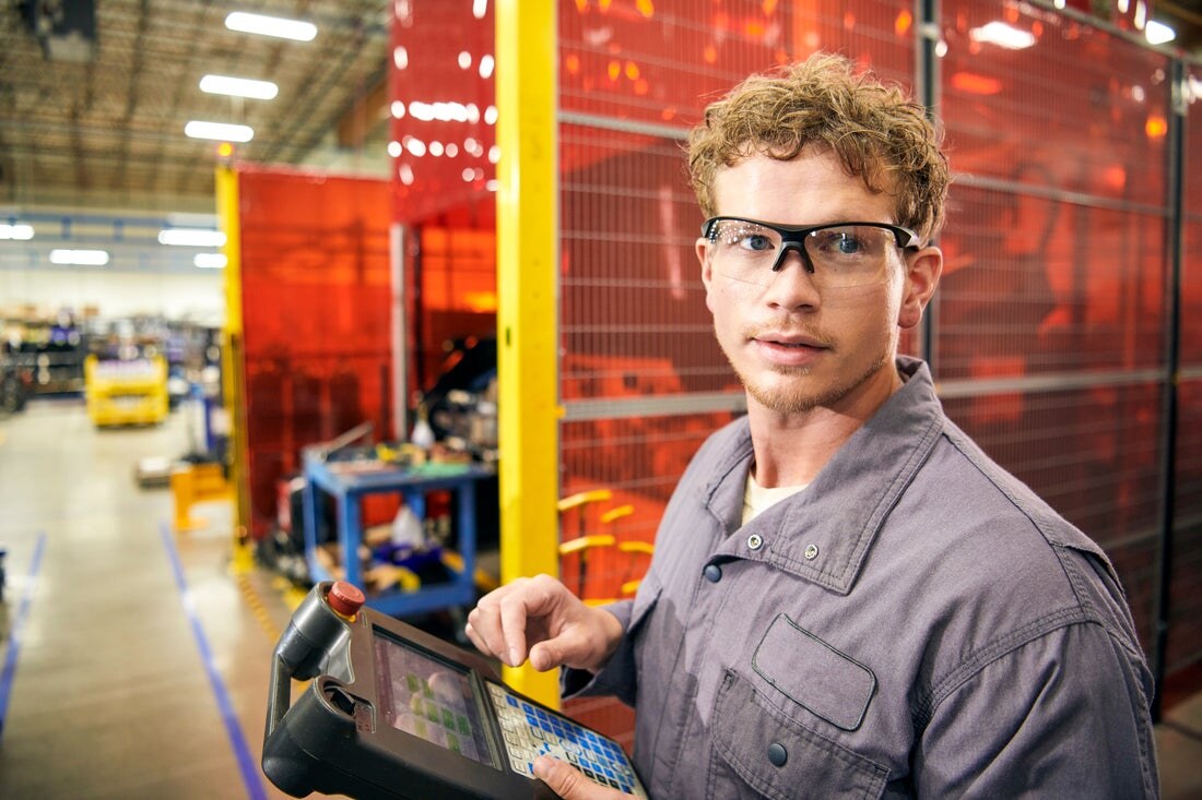 Worker wearing clear rated safety glasses on a factory floor